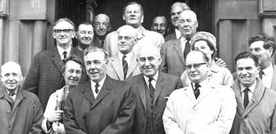 Council Water Trip
Helensburgh Town Council members and officials on the steps of the Municipal Buildings in East Princes Street before the last ever Water Trip in April 1968. It was the first trip for 17 years, and was a month before responsibility for the town's water passed to the Lower Clyde Water Board. The water scheme was inaugurated 100 years earlier. Pictured from left are George Primrose, Councillors Norman Glen and Edith Garty, Burgh Surveyor Jim McColm and behind him Parks Superintendent Tom McColl, Councillors John Langan, James Urquhart and behind him Ian Johnson, Provost J.McLeod Williamson and at the back Town Clerk Robert Mackay, Burgh Chamberlain Philip Mill and behind him Councillor Jae Gardiner, Bailie Alex Gillespie and ?, ?, ?.
