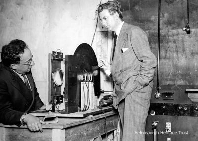 Daylight TV
An October 3 1929 photo of John Logie Baird explaining the mechanism of the television receiver while testing daylight transmission. His latest experiments in daylight transmission featured  Swedish exercises performed by an instructor transmitted to the receiver in movie form. On the left is his technical assistant, Ben Clapp.
