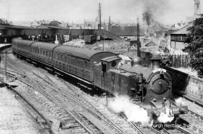 Leaving Helensburgh
LNER C16 4-4-2T No.9439 is seen pulling a passenger train out of Helensburgh Central Station in 1938. Behind is the station goods yard.
