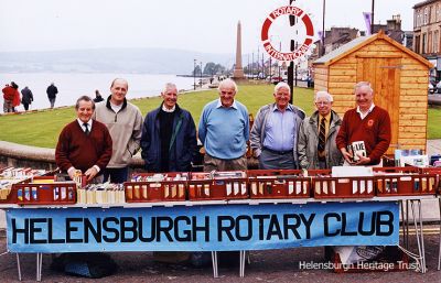 Rotary bookstall
Members of Helensburgh Rotary Club pictured running a bookstall beside the esplanade putting green in 2002. From left: Denis Taylor, Dilwyn Jones, Jim McBlane, Gordon Hattle, George Boyd, ?, and Graham Smith.
