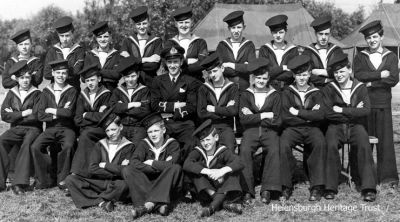 World War Two Sea Cadets
Helensburgh's Ajax Company of the Sea Cadet Corps pictured at their 1944 Summer Camp at Stanley Park, Blackpool. Back row: ?, William Hardy, Hugh Dawson, Ian McPhail, George Hood, William Fyfe, William Daly, ? Dewar, ?; middle: Alastair Clow, ? McKechnie, Jim Hosie, Thomas Dickson, Lieutenant McLean, William Paterson, Thomas Dawson, Robert Hailstones, ?; seated: Leslie Ward, Thomas Isbister, ?. Image supplied by Robert Hailstones.
