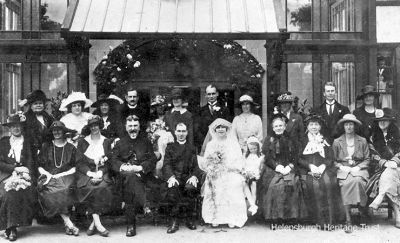 Wedding guest
John Logie Baird (2nd from right, back row), his father, the Rev John Baird (4th from left, front row), and his mother Jessie, a niece of the famous Inglis shipbuilding brothers Anthony and John, are seen in this wedding group outside the Queen's Hotel in Helensburgh on June 6 1922. The bride was JLB's sister Jeannie, known to friends as Tottie, and the groom is the Rev Neil Conley. Jessie Baird is on the bride's left, and JLB's sister Annie is immediately behind the groom. Far left back row is Anna Snodgrass (nee Inglis), aunt of Arnold Snodgrass. JLB is looking fit after a sojourn at a health spa. The Conleys' son Norman (b.1926) moved from Glasgow to Helensburgh about 2002 and passed away early in 2009. Norman's daughter Laura Conley (b.1954) is still living in the burgh.
