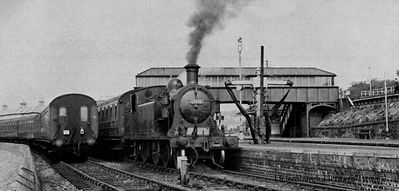 Craigendoran Station
Looking west toward Craigendoran Low Level Station. The tank engine Class C15 4-4-2T no.67474 is in the pier platform on the Craigendoran to Arrochar push-and-pull train. On the right is the High Level Station on the West Highland Line. Image by K.R.Pirt.
