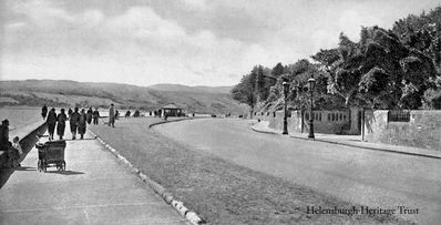 Ferniegair entrance
An old image of Helensburgh's West Esplanade, with the gateway to Ferniegair on the right, with Provost's lamps outside. Ferniegair was the family home of the Kidston family. Richard Kidston was Provost of Helensburgh from 1840-49, and Adrian M.M.G.Kidston was Provost in 1911-12. The mansion was demolished in the 1960s. Image date unknown.
