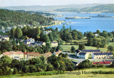 Mothballed warships
Garelochhead and the Gareloch from Whistlefield Brae, showing mothballed Royal Navy warships lying at anchor in the loch â€” a ship of the King George V battleship class in the foreground and two others of the class in the background. The first of these ships was laid up there after decommissioning in November 1949, followed by King George V (June 1950) and Duke of York (November 1951). Approval for scrapping these ships was given in April 1957, so the image date is likely to be between 1951 and 1957.
