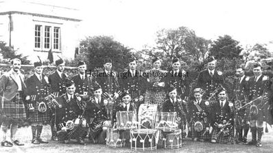 Helensburgh Pipe Band 1938
Members of Helensburgh Pipe Band at Rossdhu House, Luss, with Sir Ian Colquhoun (left) after receiving new uniforms to play at the Empire Exhibition. Standing: Pipe Major Thomas Neil, J.Strang, Watson, W.Camlin, A.MacKillop, J.Copeland, A.Hamilton, A.MacKean, T.McGregor, Pipe Sergeant T.Campbell, band secretary B.Watson; front: Stewart, Garrity, T.Fagan, Robinson, J.Cameron, J.Martin.
