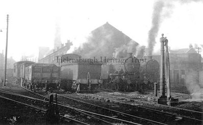 The Helensburgh Shed
Steam locomotives at the Helensburgh shed beside the Central Station, with the St Columba Church tower barely visible through the haze. Image date unknown.
