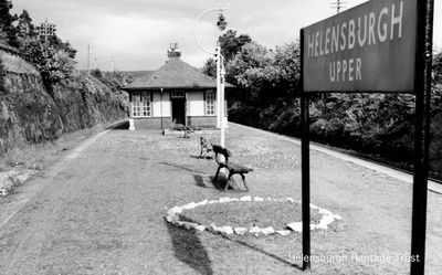 Helensburgh Upper Station
A view of Helensburgh Upper Station from the west. A very deep cutting was excavated for the station on the West Highland Railway, which opened to traffic in 1894. Like all the local upper stations except Rhu, it was originally designed to look like a Swiss chalet, and it had its own coalyard to east of Sinclair Street where the Maclachlan Road flats are now. Image circa 1960; copyright D.K.Jones Collection.
