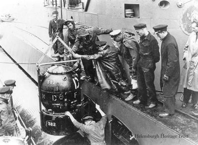 Loading mines
A Vickers T Mk3 exercise mine is loaded aboard the Dutch submarine O19 in Loch Long off Arrochar during World War Two. Picture courtesy of www.dutchsubmarines.com
