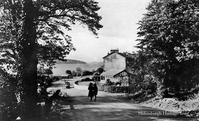 Mill Brae, Kilcreggan
A view of the lower part of the Mill Brae, the steep hill down into Kilcreggan. The low wooden house was for many years the home of Mrs Lucy Rickerman, who lived to the age of 105 before her death in 1980 and was the only person to be awarded the title of Burgess of the Burgh of Cove and Kilcreggan. She was also the oldest person ever to live in Helensburgh and district. Image circa 1962.
