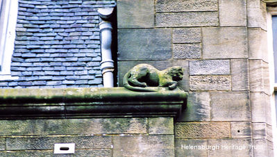 Municipal Buildings cat
This cat was a flight of fancy by architect and watercolourist Alexander Nisbet Paterson who was commissioned to design an extension to the Municipal Buildings in 1902 which was completed in 1906. The cat had become the pet of the builders, so the architect, a cat lover, immortalised it in stone on the second storey on the Sinclair Street side. As the extension housed the police station, he also added two pairs of stone handcuffs above the door. Image taken and supplied by Donald Fullarton.
