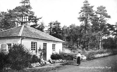 Old Toll House
A lady, possibly the then owner, stands outside the Old Toll House at the top of Sinclair Street. In 2018-19 the little building was substantially expanded and modernised, and is a private dwelling. Image date unknown.
