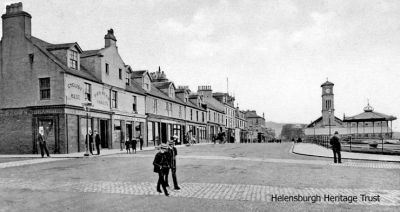 Seafront crossing
The junction of West Clyde Street and Colquhoun Street, Helensburgh, as it used to be, with a cobbled walkway across the road to the pier. On the corner, where there is now a three-storey shop and office block, is Robert Brown's 'Cyclist's Rest Pierhead Vaults' public house. Image circa 1907.
