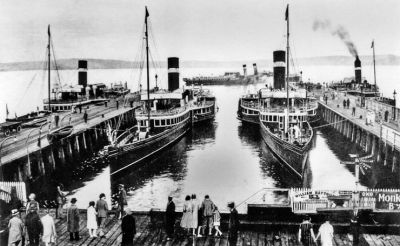 Steamers at Craigendoran
A 1933 picture of most of the LNER fleet at Craigendoran. The two which can be seen least well are the Lucy Ashton and the Jeanie Deans, while in the centre are the Talisman and the Marmion. The steamer terminal and station opened for business under the North British Railway on May 15 1882, and steamer services were finally withdrawn in 1972. The piers have since become derelict, and on the firth side of the line the station buildings are long gone.
