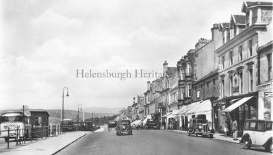 West Clyde Street looking west
View from Sinclair Street looking west, showing cars â€” some with the registration plate readable â€” a coach with 'W.Innes' on the rear, the Imperial Hotel, shops, and old lamp-posts, circa 1935.  
