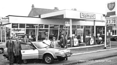 Appleyards Garage
The Appleyard Garage on East Clyde Street, on the site now occupied by Tesco Express in the 1970s. Petrol cost 79p for a gallon of four star. The staff in the pic with a Rover 2600 are (from left) to right, Bill Smith, Davie Nicholson, manager Donald Stewart, Iain Cowe, Agnes Wilson and Archie Pollock. Image by courtesy of the photographer, Brian Averell.
